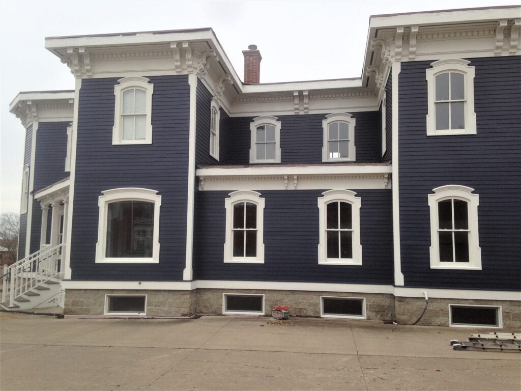 A large blue building with white trim and windows.