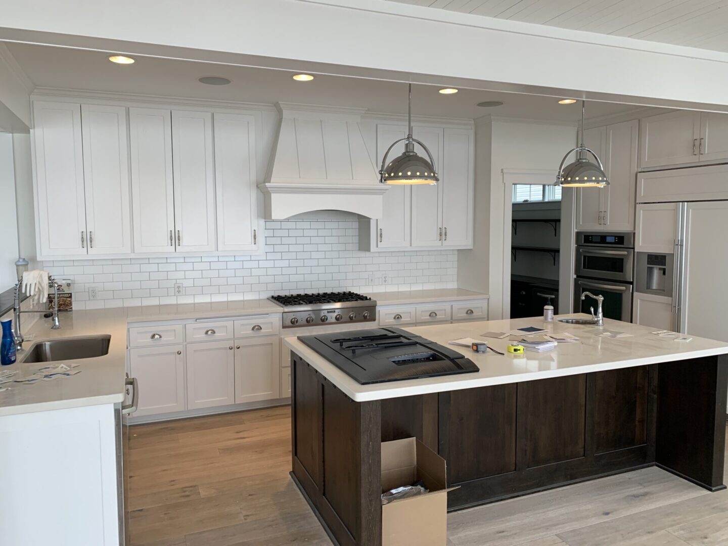 A kitchen with white cabinets and black island.