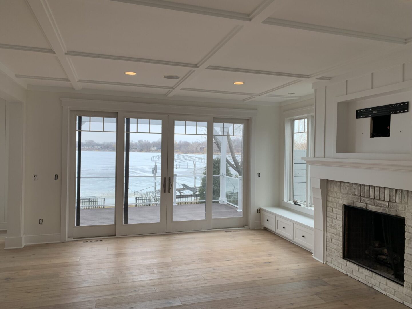 A living room with a fireplace and large windows.