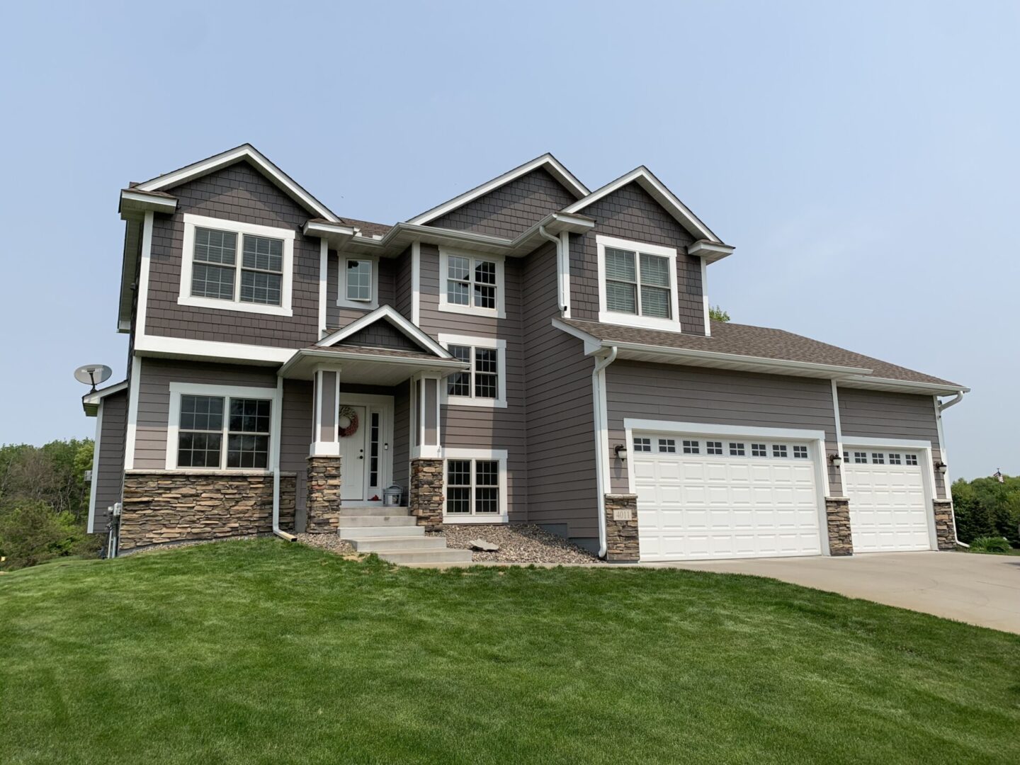 A large house with two garage doors and a lawn.