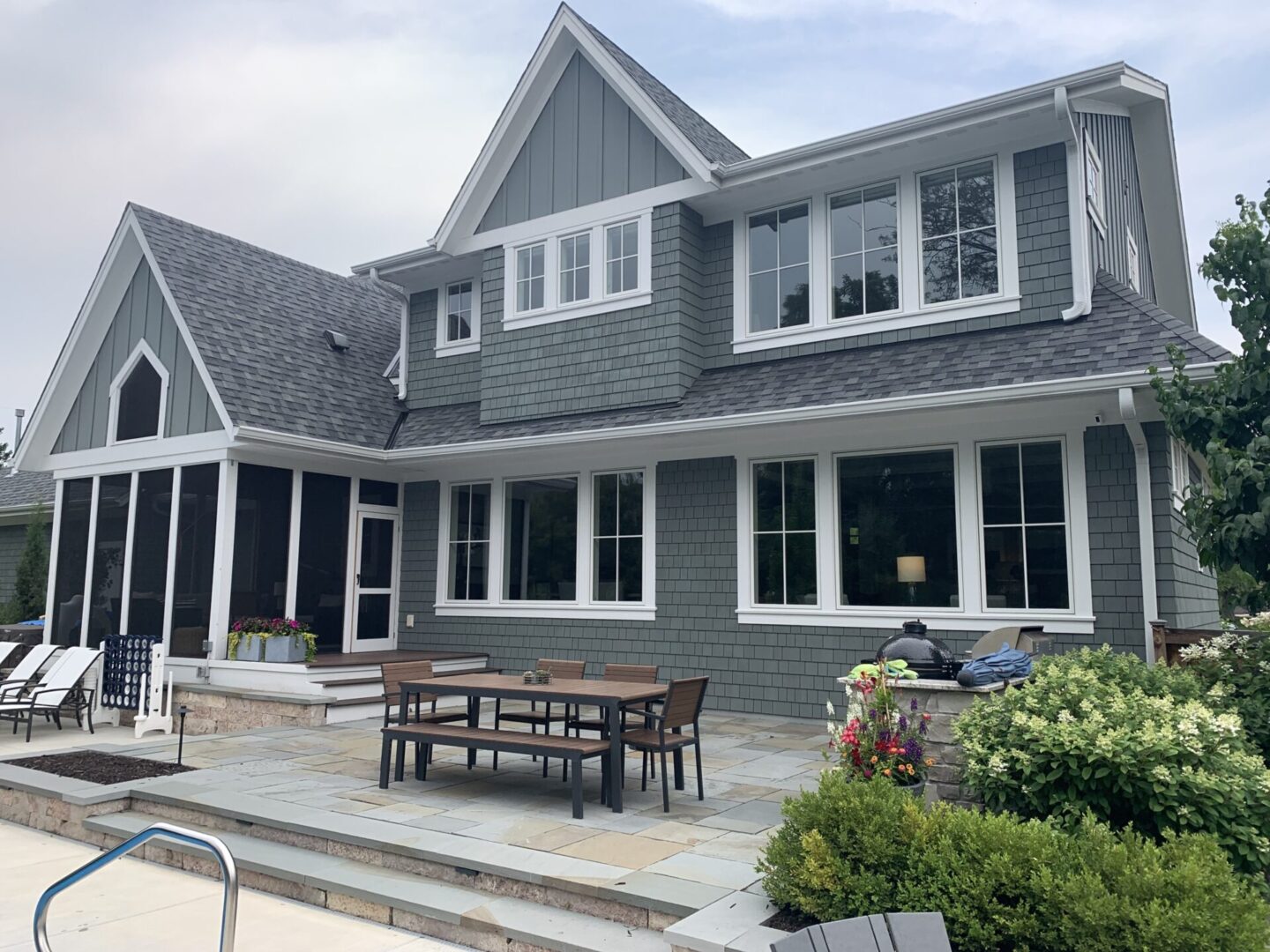 A large house with a patio and outdoor furniture.